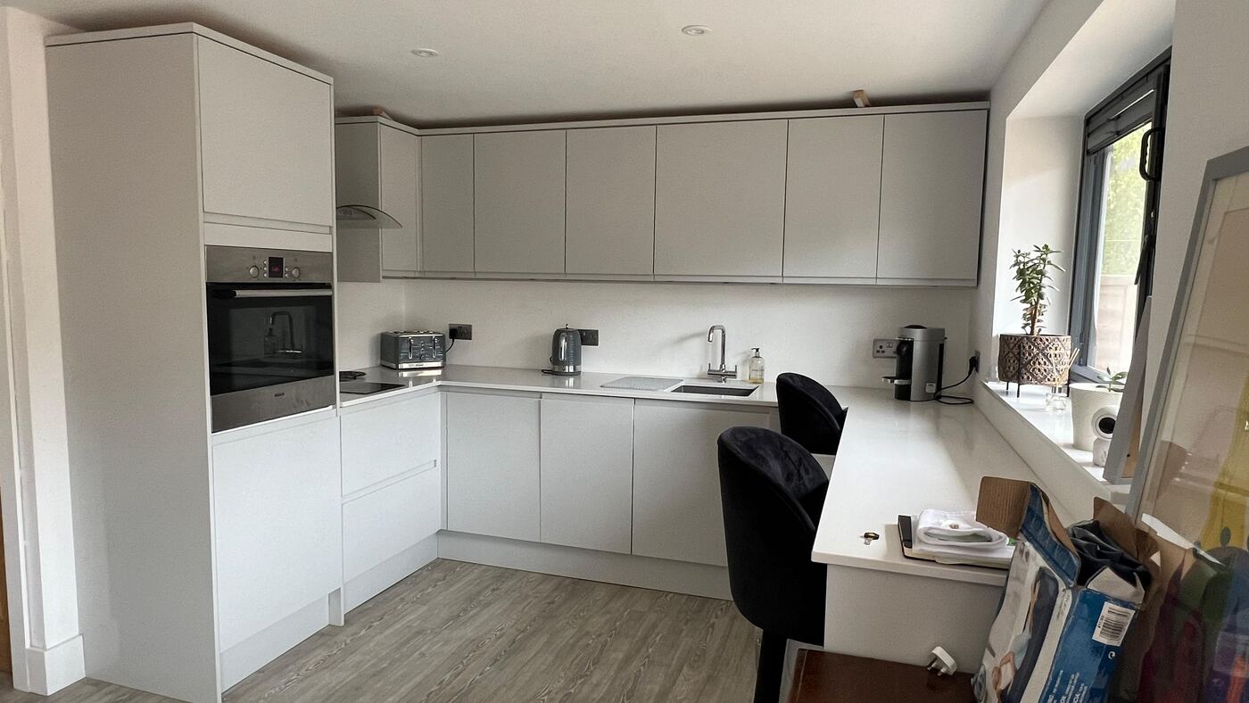 Handleless grey kitchen with quartz worktops and breakfast bar